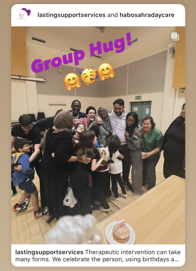 A group of people smiling together in a warm, celebratory hug.